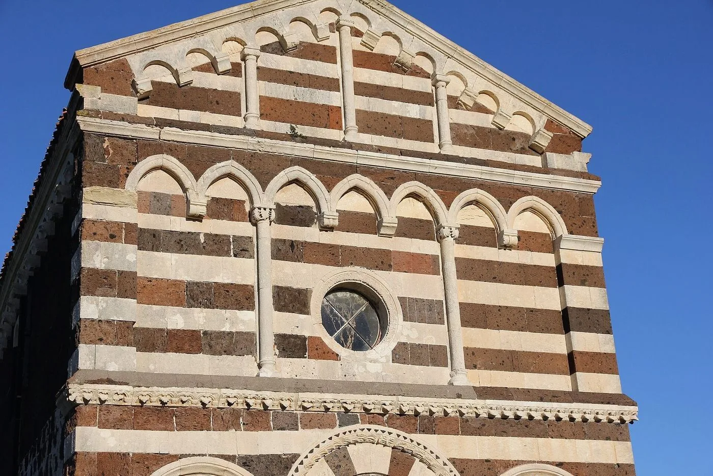 La facciata bicroma della chiesa romanica di San Pietro del Crocifisso a Bulzi